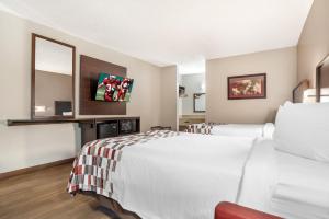 a hotel room with two beds and a mirror at Red Roof Inn Montgomery - Midtown in Montgomery