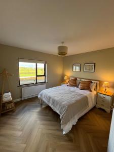 a bedroom with a large bed and a window at Woodview Cottage in Mill Loughan