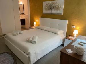 a bedroom with a large white bed with towels on it at La Rosa Blu in San Vito lo Capo
