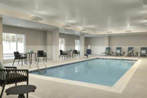 a swimming pool with chairs and tables and chairs at TownePlace Suites by Marriott Duluth in Duluth
