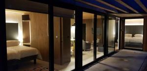 a bedroom with a bed and a room with glass walls at Otter Lodge in Gainford