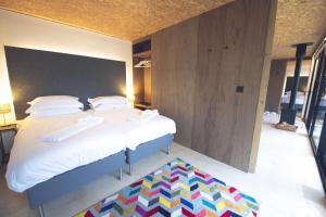 a bedroom with two beds and a colorful rug at Otter Lodge in Gainford