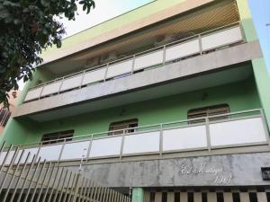 a green and white building with a balcony at Apartamento mobiliado para até 9 pessoas in Ribeirão Preto