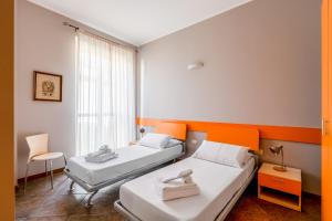 two beds in a small room with a window at Residence Due Spade - Free Parking in Melzo