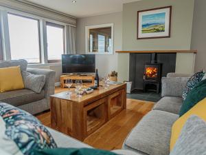 a living room with a table and a fireplace at Corsewall Castle Farm Lodges in Kirkcolm
