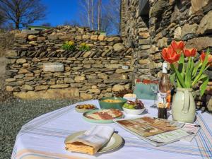 a table with plates of food and a vase of flowers at Hardriggs Bank Cottage in Kendal +21 photos
