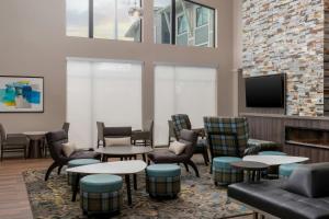a waiting room with tables and chairs and a fireplace at Residence Inn by Marriott Novato Sonoma in Novato
