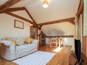 una sala de estar con un sofá y una mesa en Woodland Retreat Lodge, en Woodbridge