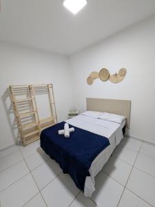 a bedroom with a bed with two white towels on it at Pousada Costa Prestige in Touros