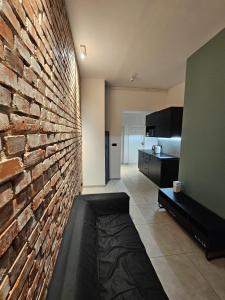 a living room with a brick wall and a couch at 8Wygodny pokój w centrum Wrocławia in Wrocław