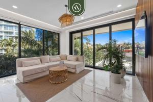 a living room with a white couch and large windows at Luxury 2 BR Condo with Dream Pools - Beach - Art in Bucerías