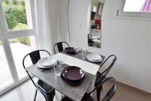 a dining room with a table and chairs and a window at Ebène studio Centre ville Climatisation Terrasse Disneyland 4 personnes et 1 bébé in Bailly-Romainvilliers