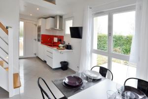 a kitchen and dining room with a table and chairs at Ebène studio Centre ville Climatisation Terrasse Disneyland 4 personnes et 1 bébé in Bailly-Romainvilliers