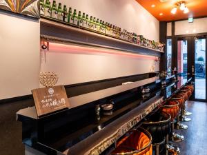 a bar with a row of chairs and bottles at APA Hotel Tsukiji Ekiminami in Tokyo +71 photos