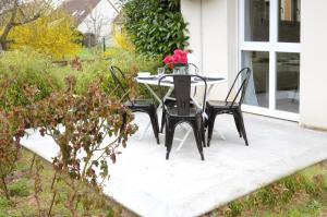 a table and chairs on a patio with flowers on it at Ebène studio Centre ville Climatisation Terrasse Disneyland 4 personnes et 1 bébé in Bailly-Romainvilliers +8 photos