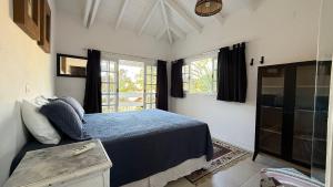 a bedroom with a blue bed and a window at Linda casa na Barra do Sahy 1 (Litoral Norte SP) in São Sebastião +72 photos