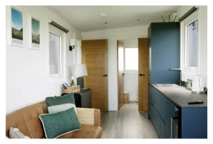 a living room with a couch and a kitchen at Luxury Glamping Cabin sleeping 4 People with Private Hot Tub and BBQ with views across the North Coast Ballycastle Pod 2 in Ballycastle