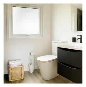 a bathroom with a toilet and a sink and a window at Luxury Glamping Cabin sleeping 4 People with Private Hot Tub and BBQ with views across the North Coast Ballycastle Pod 2 in Ballycastle