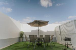Un patio con una mesa y sillas y una sombrilla. en Best Houses 115 - Faustino s House II, en Atouguia da Baleia