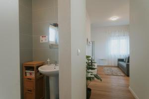 baño con lavabo y espejo y sala de estar. en Best Houses 115 - Faustino s House II, en Atouguia da Baleia 13 fotos más