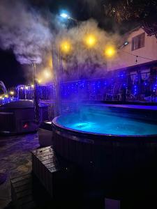 スラニックにあるPensiunea PORTAS RESORTの- 夜間の大型スイミングプール(青い照明付)