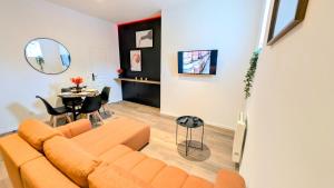 a living room with a couch and a table at Le caviste 2ème Étage in Abbeville
