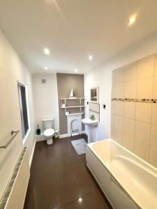a bathroom with a tub and a toilet and a sink at Summerfield House in Birmingham +31 photos