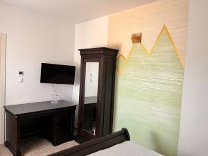 a room with a bed and a mirror and a desk at Perla Muresului in Alba Iulia