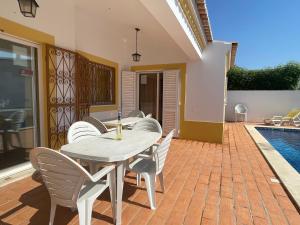 a patio with a table and chairs and a pool at Villa Ana in Albufeira