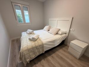 a bedroom with a bed with towels on it at Oktheway Corme in Corme-Puerto