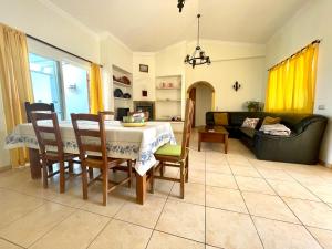 a living room with a table and chairs and a couch at Villa Ana in Albufeira