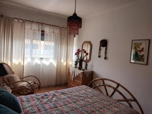 ein Schlafzimmer mit einem Bett, einem Spiegel und einem Fenster in der Unterkunft Terraço da Baía in São Martinho do Porto