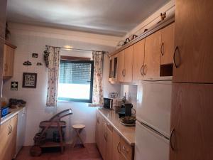 eine Küche mit einem weißen Kühlschrank und einem Fenster in der Unterkunft Terraço da Baía in São Martinho do Porto