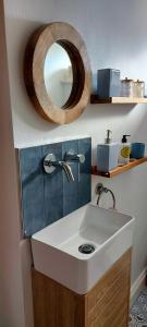 a bathroom with a white sink and a mirror at The Snug in Haddenham