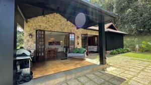 un patio cubierto con mesa y silla en Casa 04 Vale Boa Vista - Casa Charmosa com 3 Suítes e Acesso à Área de Lazer Completa de Condomínio, en Teresópolis