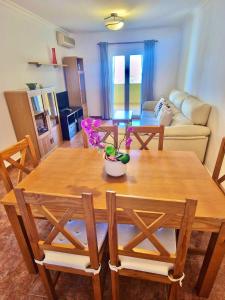 een woonkamer met een houten tafel en stoelen bij Apartamento Milenio Nerja in Nerja