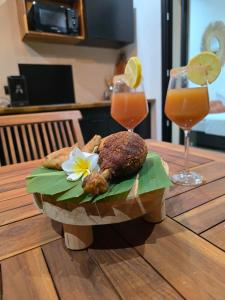 a plate of food on a wooden table with two drinks at Noa lodge in Saint-Louis