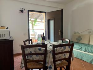a dining room table with two chairs and a bottle of wine at Casa LiSa in Cala Gonone