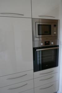 een keuken met een magnetron en een fornuis bij Le Green Set in Pornic