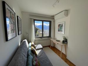un soggiorno con un divano e una finestra di Casa Ai Lupi with Panoramic view a Gordola