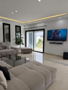 a living room with a couch and a flat screen tv at Villa ander in Hammamet