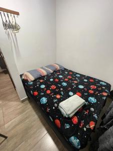 Cama en la esquina de una habitación con colcha en Alojamiento las palmas, en Medellín