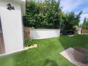 d'un jardin avec de l'herbe verte et un mur blanc. dans l'établissement Sublime Villa Récente d'Architect T5 & Piscine & 5 pkg, à Cabriès