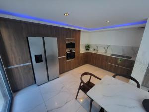 La cuisine est équipée d'une table, d'une cuisinière et d'un réfrigérateur. dans l'établissement Sublime Villa Récente d'Architect T5 & Piscine & 5 pkg, à Cabriès 8 autres photos