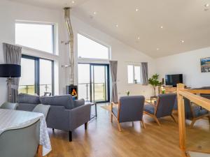 a living room with a couch and chairs and a fireplace at Jacana in Perranporth