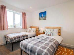 a bedroom with two beds and a window at Jacana in Perranporth