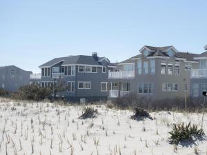 a house on the beach in front of a building at Ocean Front, Wi-Fi, Atlantic Views, 10 Beach Badges And Chairs, Outdoor Shower, Jacuzzi-Jet Tub, Decks Ping Pong Table, Private Yard,ship Bottom, in Ship Bottom