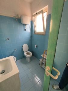 a bathroom with a toilet and a sink and a window at En Allusi Apartment in Badesi