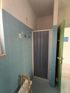 a bathroom with a shower with blue tiles at En Allusi Apartment in Badesi