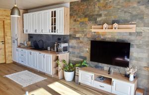 a kitchen with white cabinets and a stone wall at Apartmán Hrabušice I1 in Hrabušice